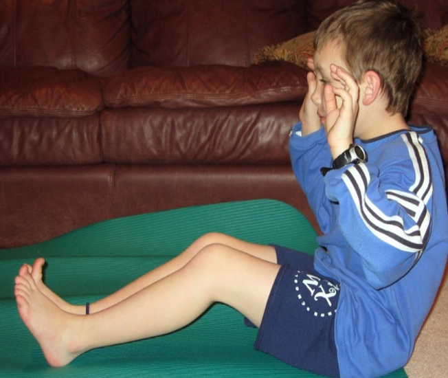 Child with tight hamstrings sitting on the ground